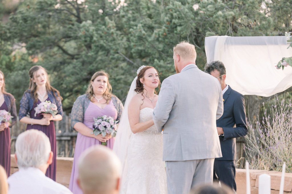 A bride and groom from New Mexico gaze lovingly at each other while they give their vows during their wedding ceremony at the Four Seasons New Mexico wedding venue, shot by New Mexico wedding photographers in Albuquerque.