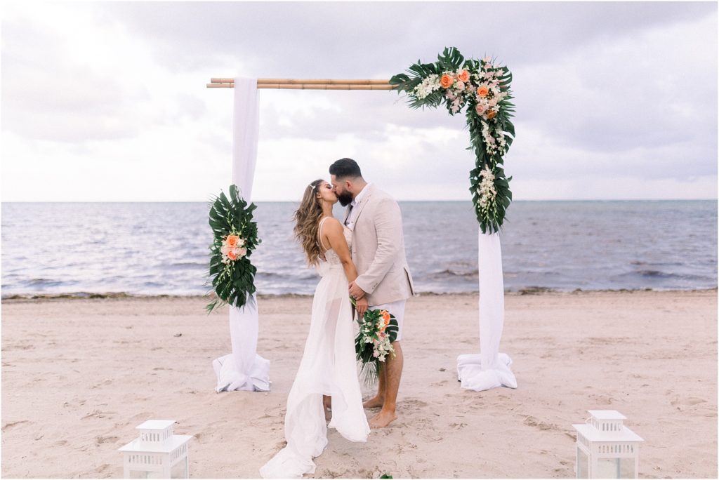 Local wedding photographer and adventure photographer in Albuquerque, New Mexico, Shayla Cristine Photography captures Lais DeLeon and husband Dr. Beau Hightower sharing a kiss on the beach after their outdoor wedding ceremony and beach elopement. 