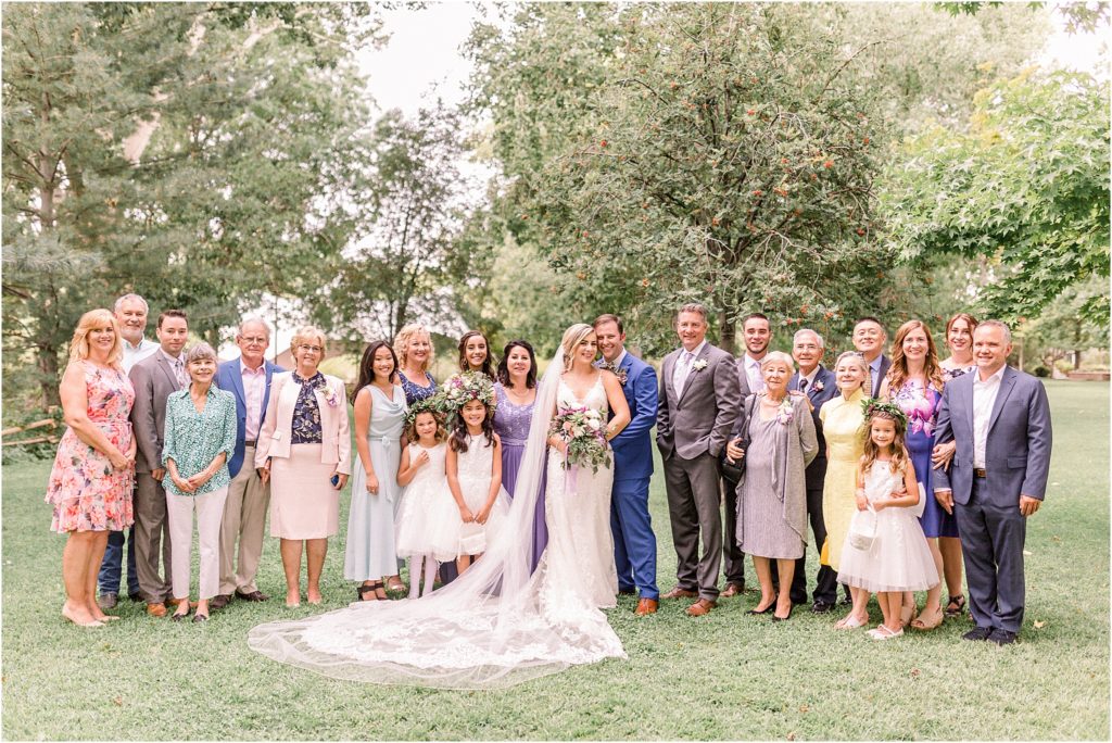 The whole beautiful wedding party and the bride and groom's family members, posing in the natural light after their outdoor wedding ceremony, and before the wedding reception at the Japanese Gardens of the ABQ BioPark in New Mexico - by Shayla Cristine Photography, the best local wedding photography team. 