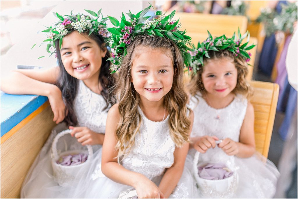 Adorable flower girls with flower crowns ready for the outdoor wedding ceremony in Albuquerque New Mexico, grinning at Shayla Cristine Photography's camera. 
