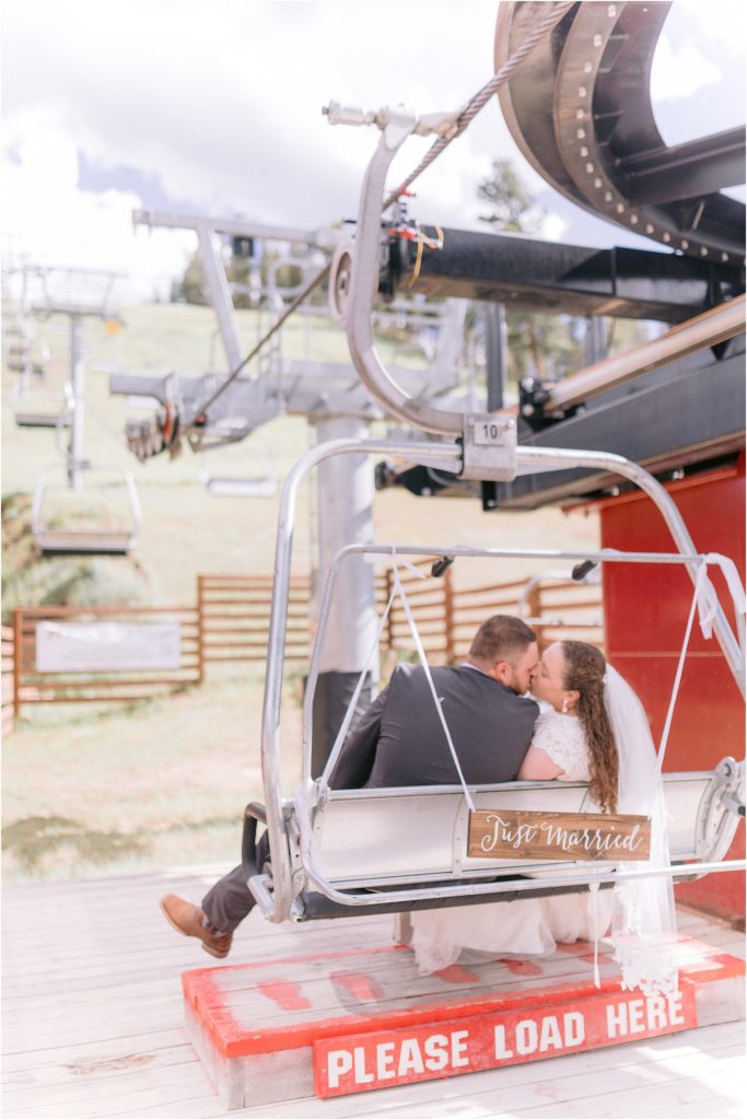 One final shot of the bride in her lace bridal gown and the groom in his tailored tux on a ski lift in New Mexico captured by Albuquerque's best wedding photographers, Shayla Cristine Photography.