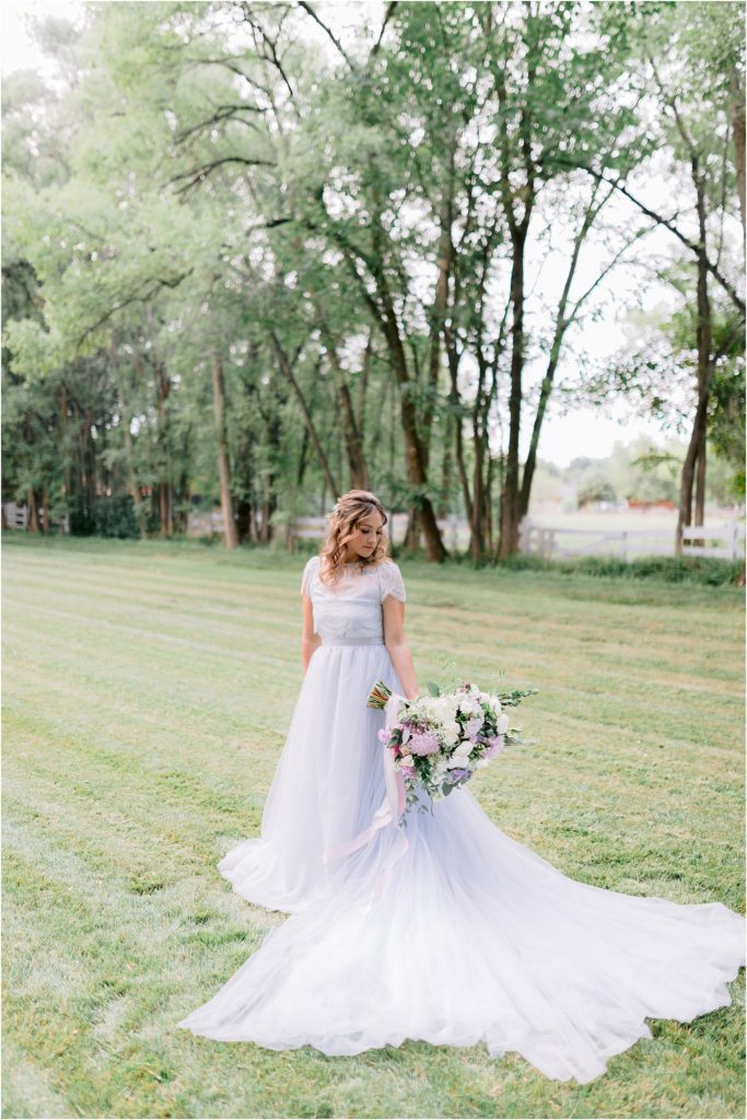One final shot of the model bride posing outdoors with her bridal bouquet and in her wedding gown, styled by local wedding businesses and photographed by New Mexico's Shayla Cristine Photography.