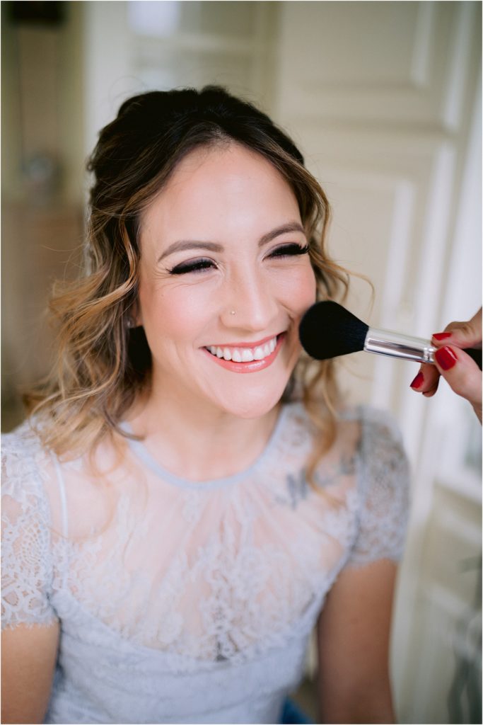 The model bride smiling wide as she gets her bridal makeup done, captured by Albuquerque's favorite wedding photographer, Shayla Cristine Photography.