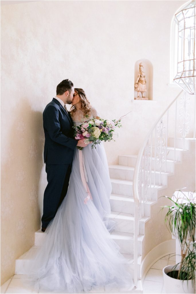 The bride and groom models share a kiss in the wedding venue in New Mexico, captured by Albuquerque's best wedding photographer, Shayla Cristine Photography.
